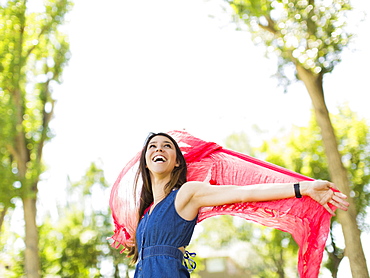 Young woman playing with scarf in park, Salt Lake City, Utah, USA