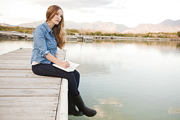 Portrait of young woman sitting on jetty, Salt Lake City, Utah