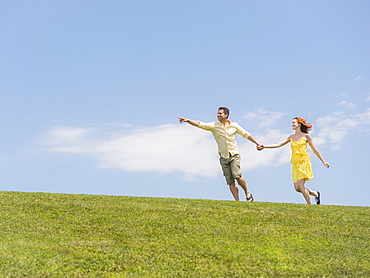 Couple running on meadow, USA, New Jersey, Mendham