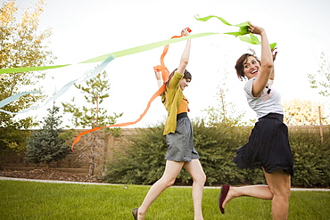 Two happy female friends playing in domestic garden