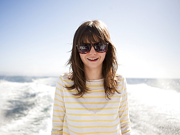 Portrait of young woman in sunglasses in front of sea