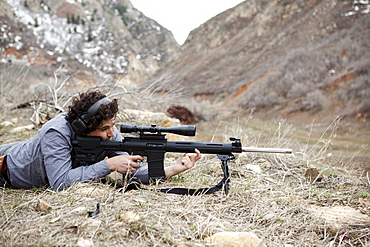 Man lying on front with weapon