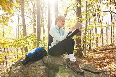 Female hiker using digital tablet in forest