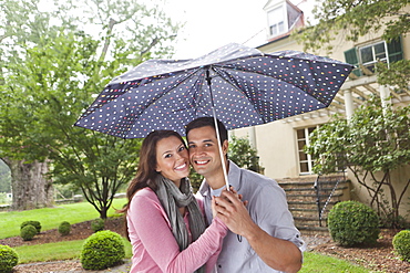 USA, New Jersey, Portrait of couple holding umbrella