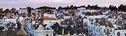 Italy, Apulia, Alberobello, Old town panorama of old trulli houses at sunset