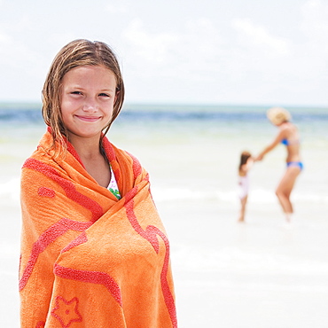 Girl wrapped in towel on beach