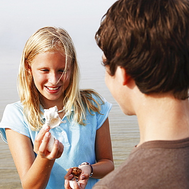 Girl showing shell to friend