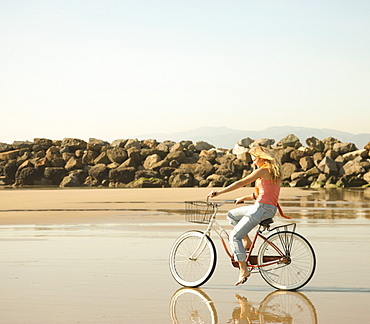 Woman riding bicycle on beach