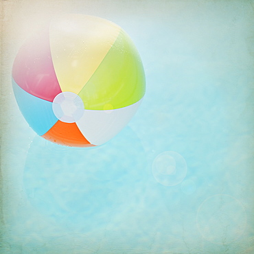 Close up of striped beach ball against water surface