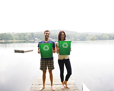 USA, New York, Putnam Valley, Roaring Brook Lake, Couple standing on pier with recycling bins