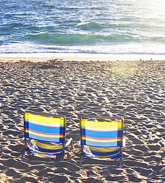 Empty beach chairs on sand