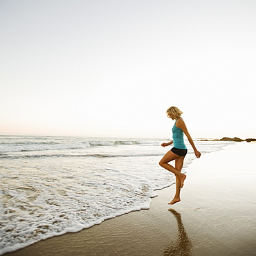 Portrait of woman running on beach