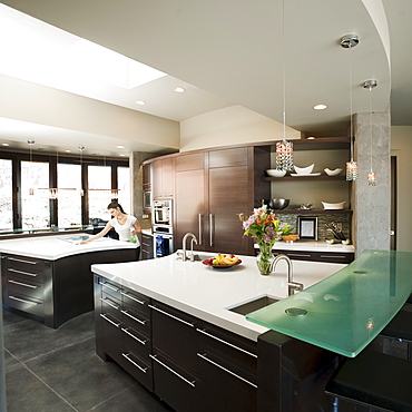 Young woman bustling around in modern domestic kitchen