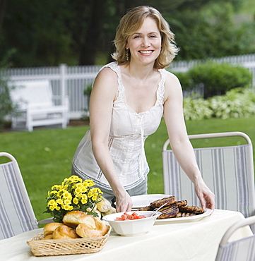 Woman setting table outdoors