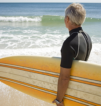 Man holding surfboard at beach