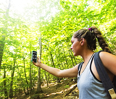 Female hiker looking at compass on phone