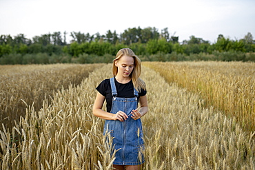 Young woman wearing overall dress in wheat field