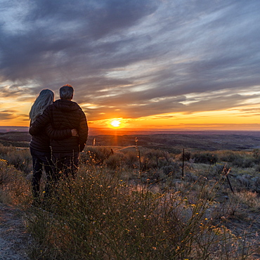 Couple in field at sunset at Boise Foothills in Boise, Idaho, United States of America