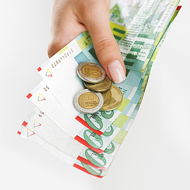 Close up studio shot of woman's hand holding money