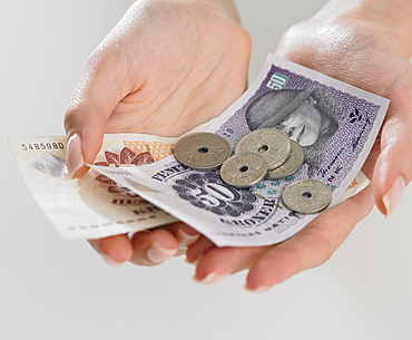 Close up studio shot of woman's hand holding money