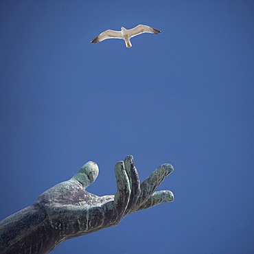 Hand of statue with flying bird