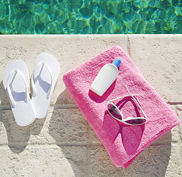 Sandals and towel at poolside