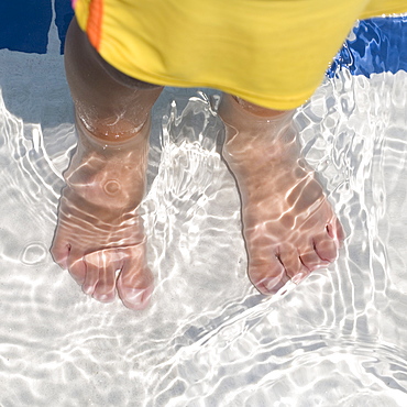 Child's feet standing in water