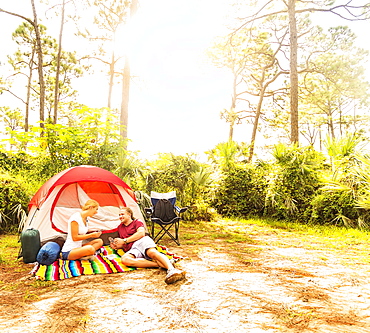 Couple playing cards in front of tent, Tequesta, Florida