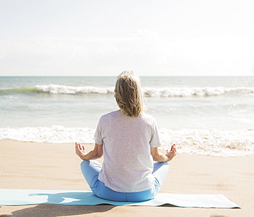 Senior woman practicing yoga on beach, Jupiter, Florida