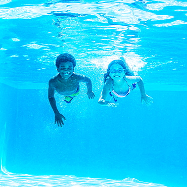 Girl and boy ( 6-7, 8-9) swimming