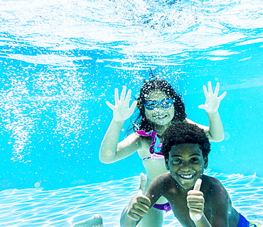 Girl and boy ( 6-7, 8-9) swimming