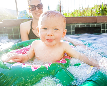 Baby boy (18-23 months) playing in swimming pool with his mother, USA, Utah, Park City 