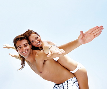 Young attractive couple enjoying summer holiday on beach