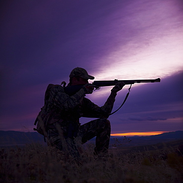 Hunter pointing his rifle