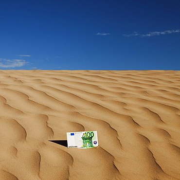 100 euro bill on sand in desert