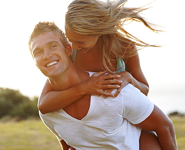 Man giving girlfriend a piggy back ride