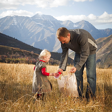 Father and child picking up litter