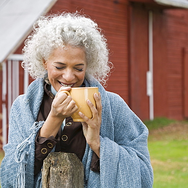 Woman holding mug outside