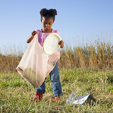 Young girl picking up litter