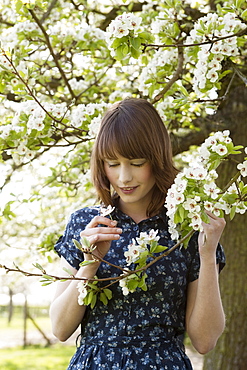 Portrait of young woman in blooming orchard