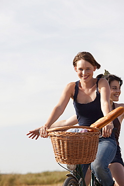 Young women on bikes on country road