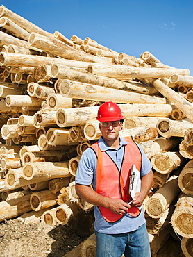 Engineer in front of stack of timber