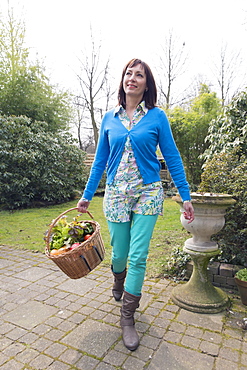 Mature woman with fresh vegetables in basket, Venlo, Netherlands