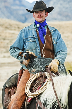 Cowboy and dog on horse