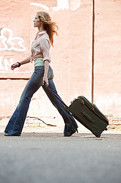 A woman walking with a suitcase