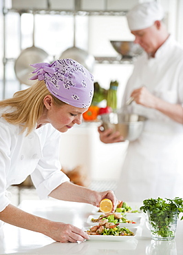 Chefs making salad in a kitchen