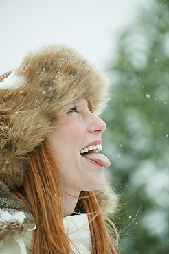 Woman catching snow on tongue