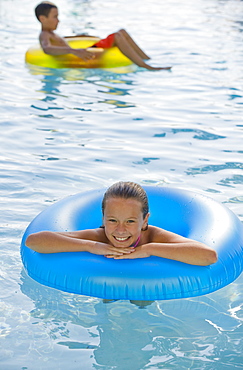 Children playing with inflatable tubes in swimming pool