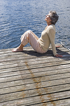 Senior woman sitting on dock