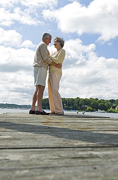 Senior couple hugging on dock